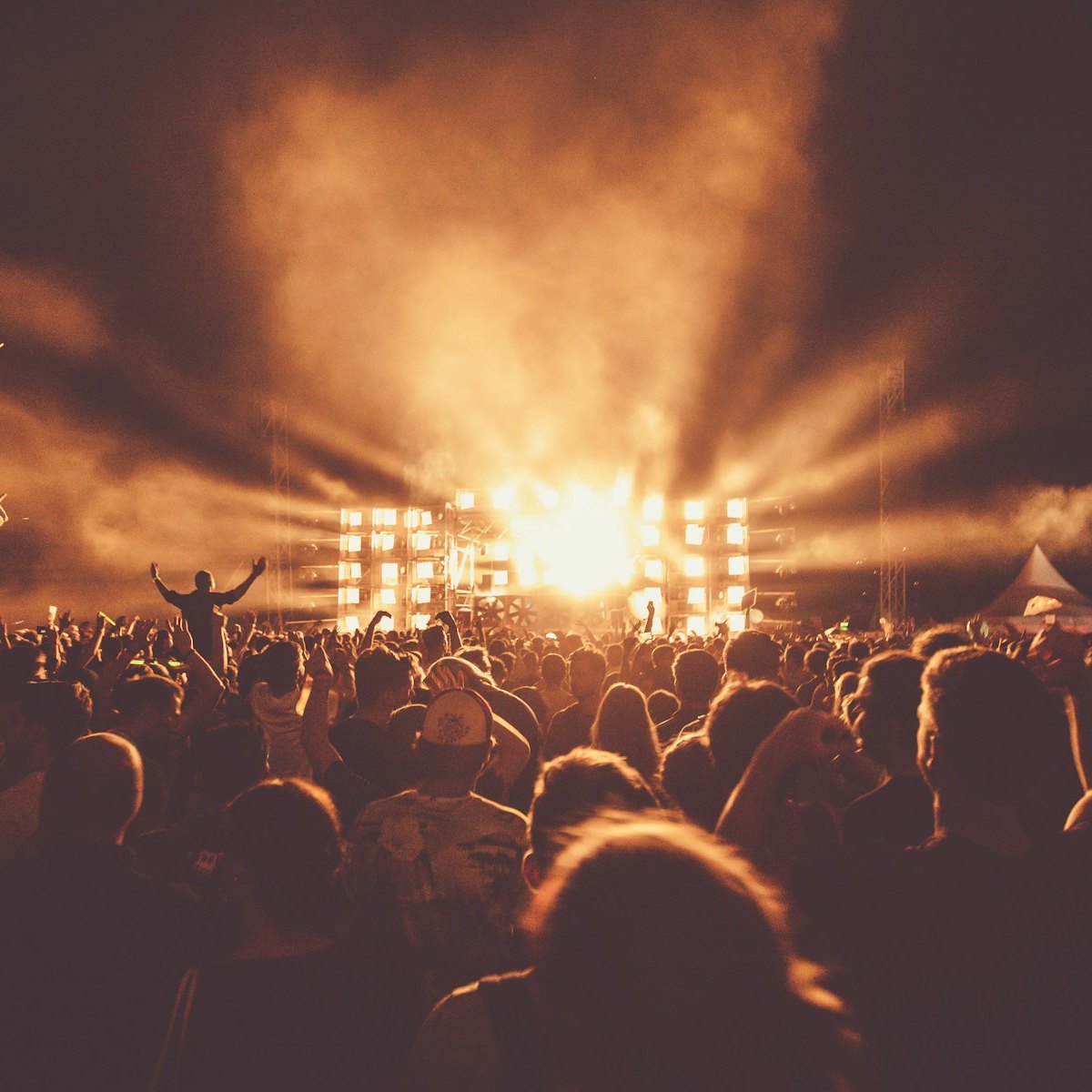 Night festival crowd under amber stage lights